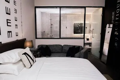 a bedroom with a white bed and a couch at M Boutique Kampar in Kampar