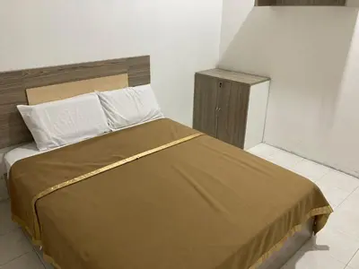 a bedroom with a large bed with a brown blanket at Walking Distance To The Beach, Pangkor in Pangkor