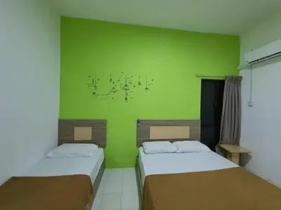 two beds in a room with a green wall at Walking Distance To The Beach, Pangkor in Pangkor
