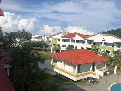 a building with a red roof next to a body of water at Walking Distance To The Beach, Pangkor in Pangkor
