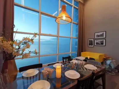 a dining room with a table and a large window at Maritime Suites Holiday Rental in George Town