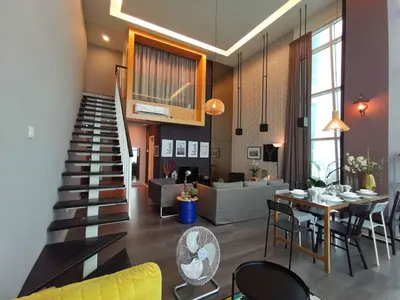 a living room with a staircase and a table and chairs at Maritime Suites Holiday Rental in George Town