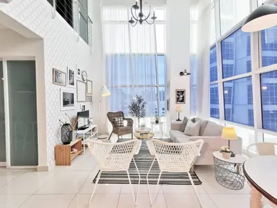 a living room with white furniture and large windows at Maritime Suites Holiday Rental in George Town