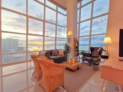 a living room filled with furniture and large windows at Maritime Suites Holiday Rental in George Town