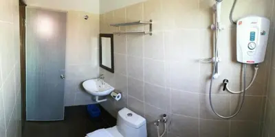 a bathroom with a shower and a toilet and a sink at JQ BL Hotel, Ipoh in Ipoh