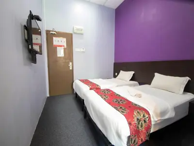 two beds in a room with purple and purple walls at JQ BL Hotel, Ipoh in Ipoh
