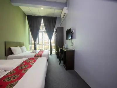 a hotel room with two beds and a desk at JQ BL Hotel, Ipoh in Ipoh