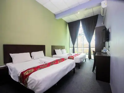 a hotel room with two beds and a television at JQ BL Hotel, Ipoh in Ipoh