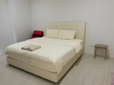 a white bed in a room with a white wall at By The Sea at Batu Ferringhi Penang in Batu Ferringhi