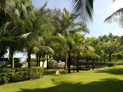 a park with palm trees and a picnic table at By The Sea at Batu Ferringhi Penang in Batu Ferringhi