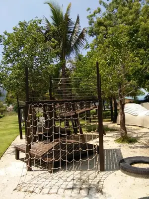 a bird cage in a park with a tree at By The Sea at Batu Ferringhi Penang in Batu Ferringhi