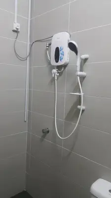 a shower in a bathroom with a hair dryer on the wall at Gerik The Great RestHouse in Gerik