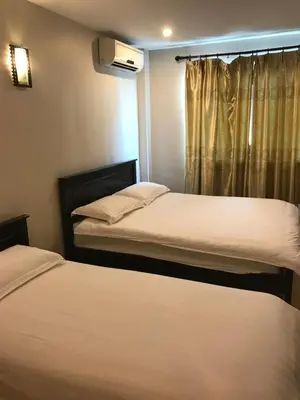 two beds in a small room with a window at Se One Hotel in Butterworth