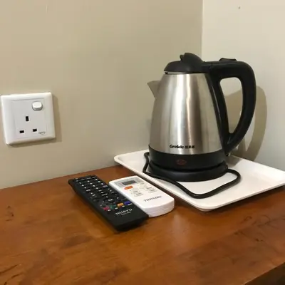 a tea kettle and a remote control on a counter at Se One Hotel in Butterworth