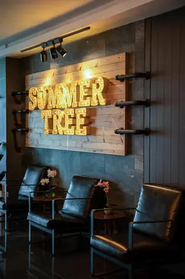 a hotel lobby with chairs and a sign that reads summer rise at Summer Tree Hotel Penang in George Town