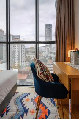 a bedroom with a desk and a chair and a window at Summer Tree Hotel Penang in George Town