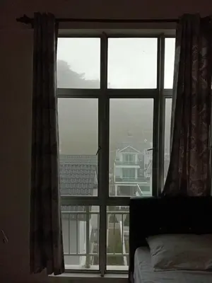 a bedroom window with a view of a city at Astana Barrington Square Goldenhills Pasar Malam Cameron Highlands in Cameron Highlands