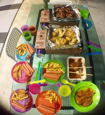 a table with food and plates of food on it at Hotel Flora Plus in Cameron Highlands