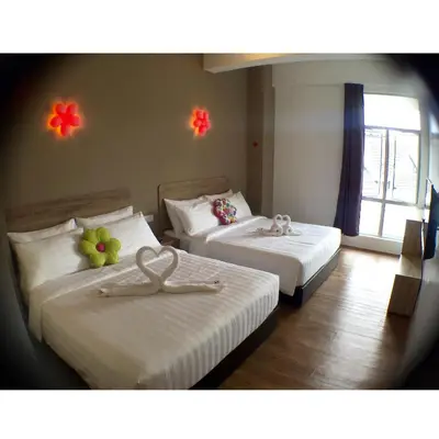 two beds in a hotel room with flowers on them at Hotel Flora Plus in Cameron Highlands