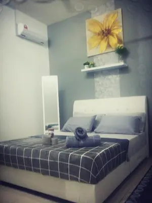 a bedroom with a bed with a yellow flower on the wall at Fahaz Lumut Homestay in Lumut