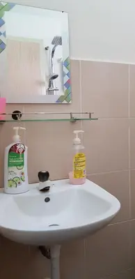 a white sink in a bathroom with a mirror at Fahaz Lumut Homestay in Lumut