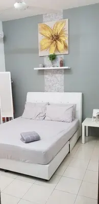 a white bedroom with a white bed in a room at Fahaz Lumut Homestay in Lumut