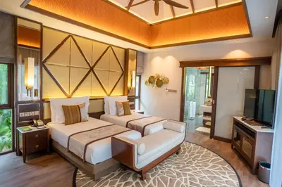a hotel room with two beds and a television at The Banjaran Hotsprings Retreat in Ipoh