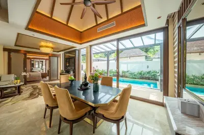 a dining room with a table and chairs and a pool at The Banjaran Hotsprings Retreat in Ipoh