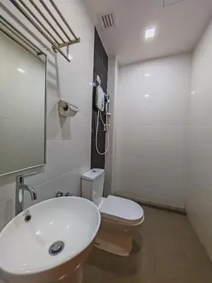 a bathroom with a white sink and a toilet at Citrine Hotel in Seri Iskandar