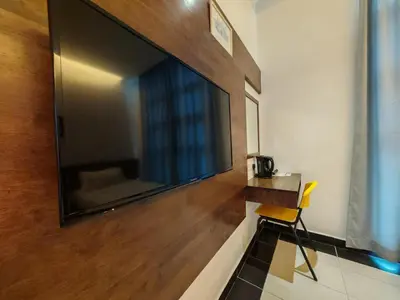 a large flat screen tv hanging on a wall at Citrine Hotel in Seri Iskandar