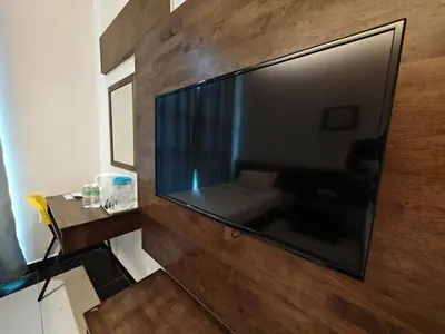 a large flat screen tv hanging on a wall at Citrine Hotel in Seri Iskandar