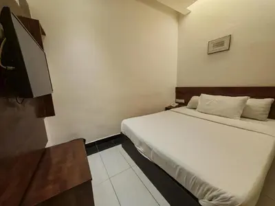 a bedroom with a bed and a flat screen tv at Citrine Hotel in Seri Iskandar