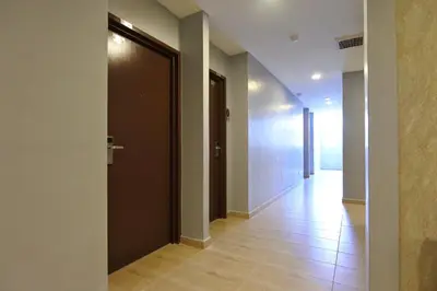 an empty hallway with a door and a tile floor at Hotel Dutaria in Ipoh