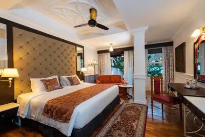 a hotel room with a large bed and a desk at Century Pines Resort Cameron Highlands in Cameron Highlands