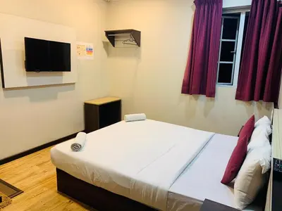 a bedroom with a large bed and a flat screen tv at Zermatt Hotel in Cameron Highlands