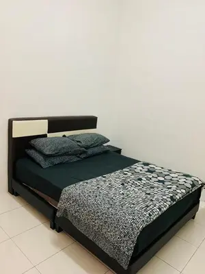 a bedroom with a bed with a black bed frame at Zahara Homestay in Cameron Highlands