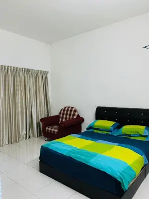 a bedroom with a bed and a chair in it at Zahara Homestay in Cameron Highlands