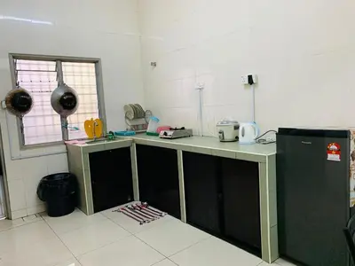 a kitchen with a counter in the middle of a room at Zahara Homestay in Cameron Highlands
