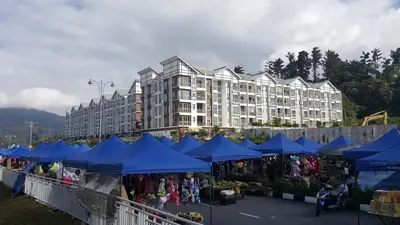 a market with blue umbrellas in front of a building at My Home Apartment @ Golden Hills in Cameron Highlands