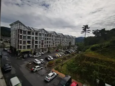 a parking lot with cars parked in front of a building at My Home Apartment @ Golden Hills in Cameron Highlands