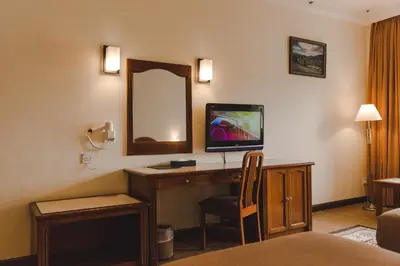 a hotel room with a desk with a tv and a mirror at Heritage Hotel Cameron Highlands in Cameron Highlands