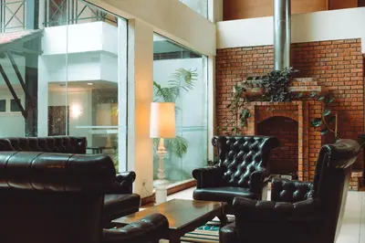 a living room with leather chairs and a fireplace at Heritage Hotel Cameron Highlands in Cameron Highlands