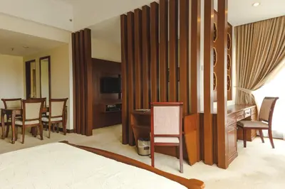 a hotel room with a bed and a table and chairs at Heritage Hotel Cameron Highlands in Cameron Highlands