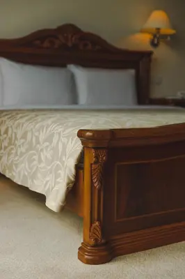 a bed with a wooden frame and white sheets at Heritage Hotel Cameron Highlands in Cameron Highlands