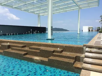 a swimming pool with a view of the ocean at Southbay Plaza Condominium in Bayan Lepas