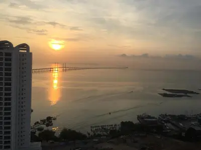 a sunset view of a bridge over the water at Southbay Plaza Condominium in Bayan Lepas