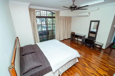 a bedroom with a bed and a desk and a window at GLYSM Tambun Stay in Ipoh
