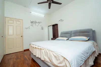 a bedroom with a large bed with a ceiling fan at GLYSM Tambun Stay in Ipoh