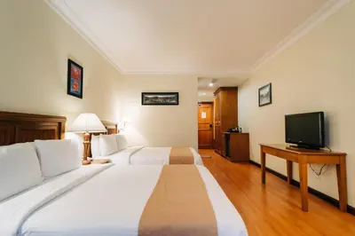 a hotel room with two beds and a television at Hotel De' La Ferns, Cameron Highlands in Cameron Highlands