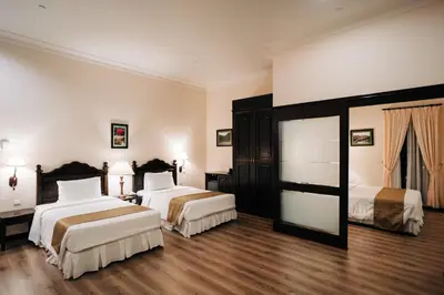 a hotel room with two beds and a mirror at Hotel De' La Ferns, Cameron Highlands in Cameron Highlands